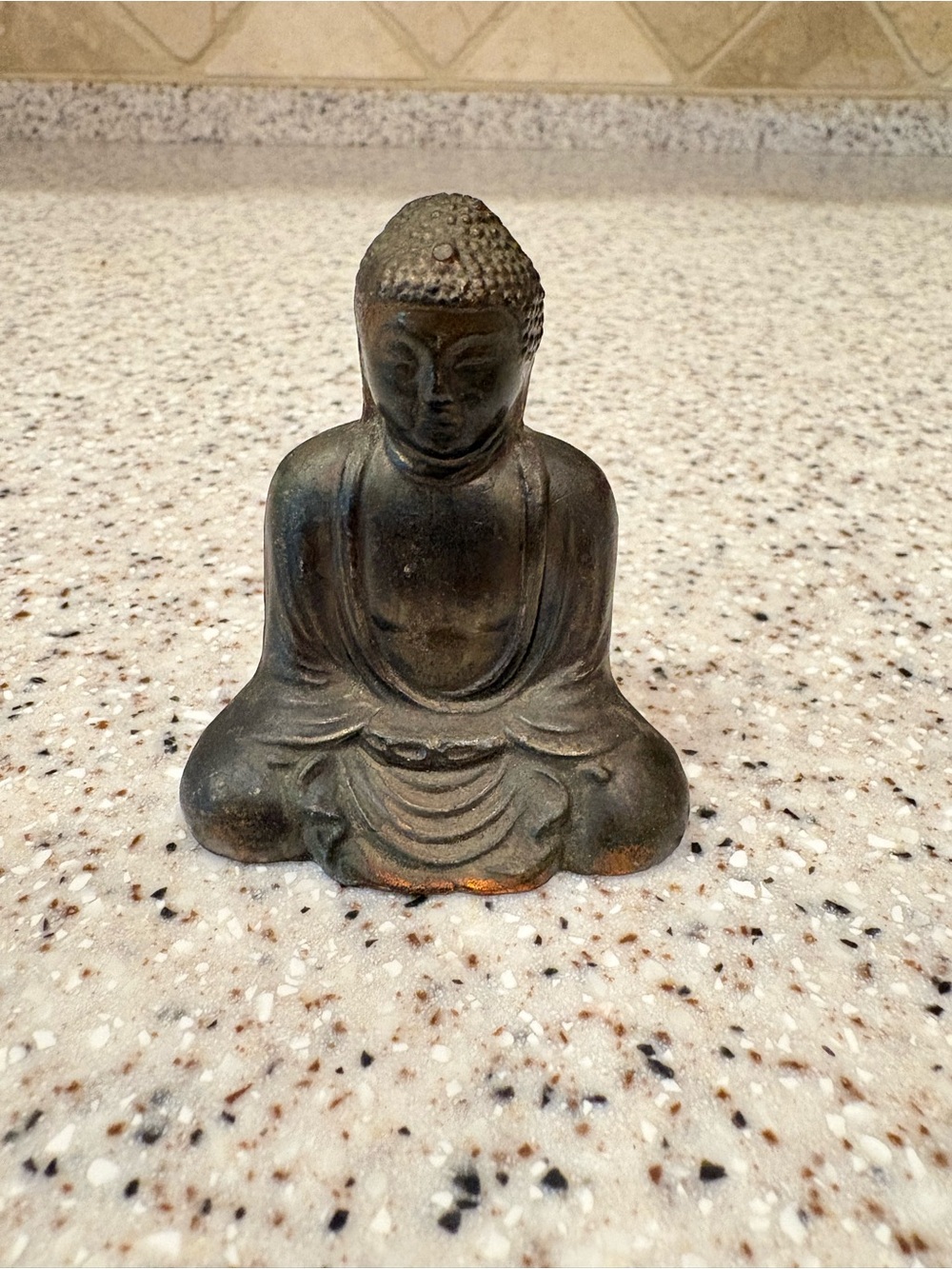 Dark metal statue appears to be a vintage East Asia Buddha